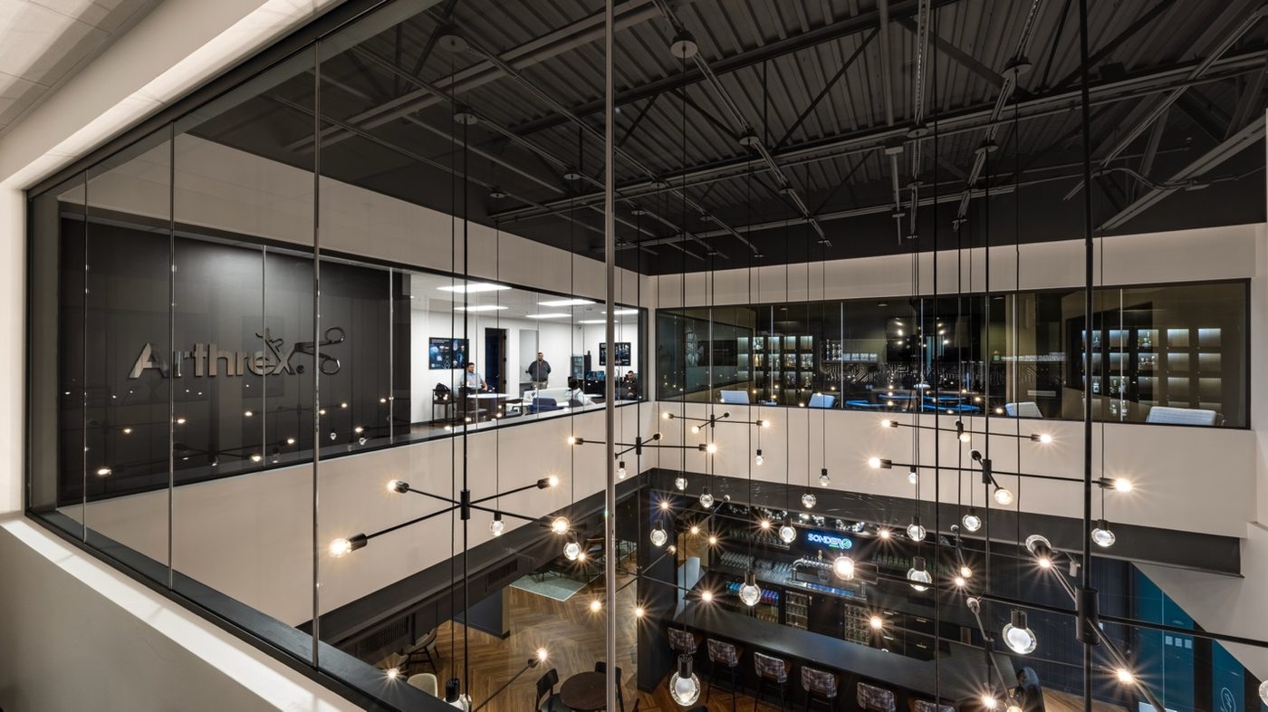Revelance two-story atrium with modern chandelier and executive offices