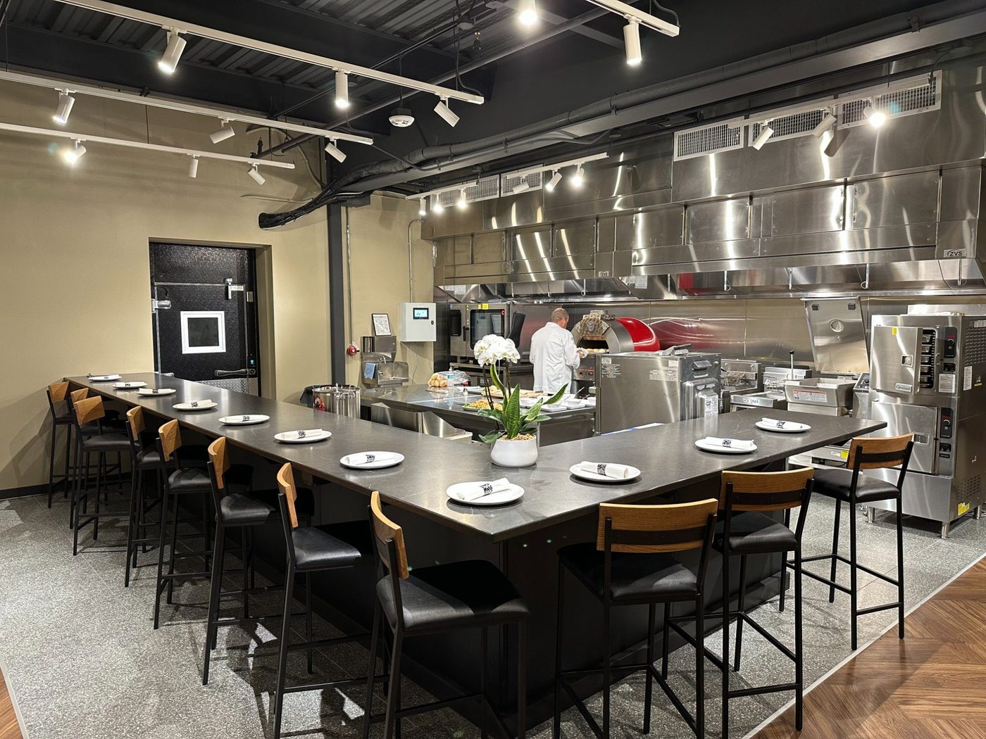 Full view of the Zink Culinary Center at Revelance — commercial kitchen with chef working and U-shaped tasting counter