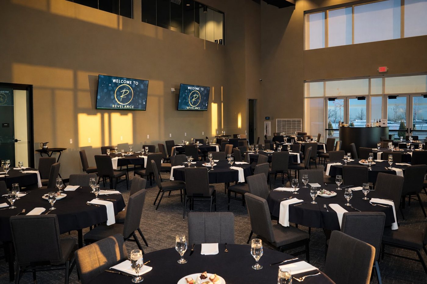 The Revel Room event space at Revelance set for a banquet with golden light