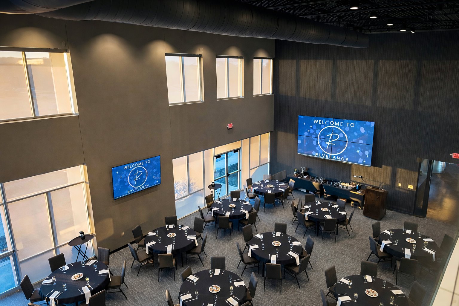 Aerial view of The Revel Room banquet setup with video wall and two-story windows